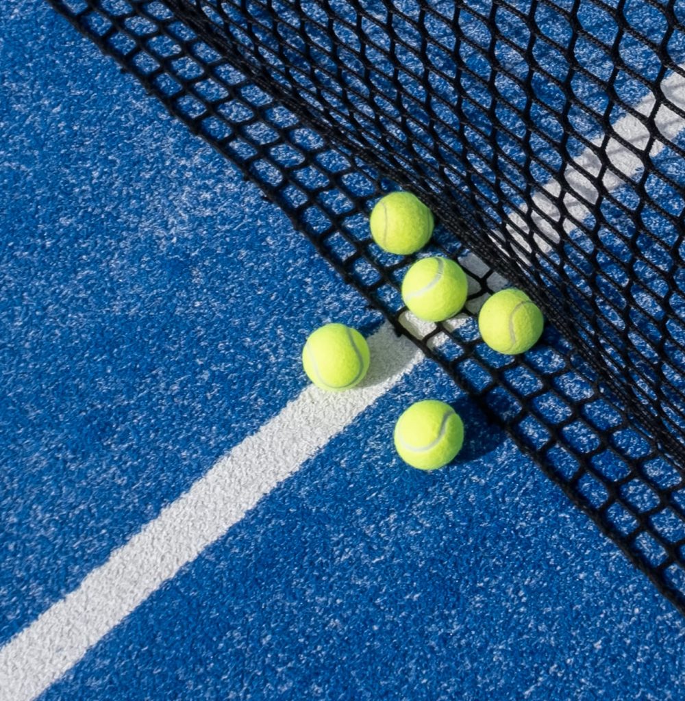 paddle-tennis-balls-by-the-net-on-a-blue-paddle-te-2023-08-21-22-40-35-utc